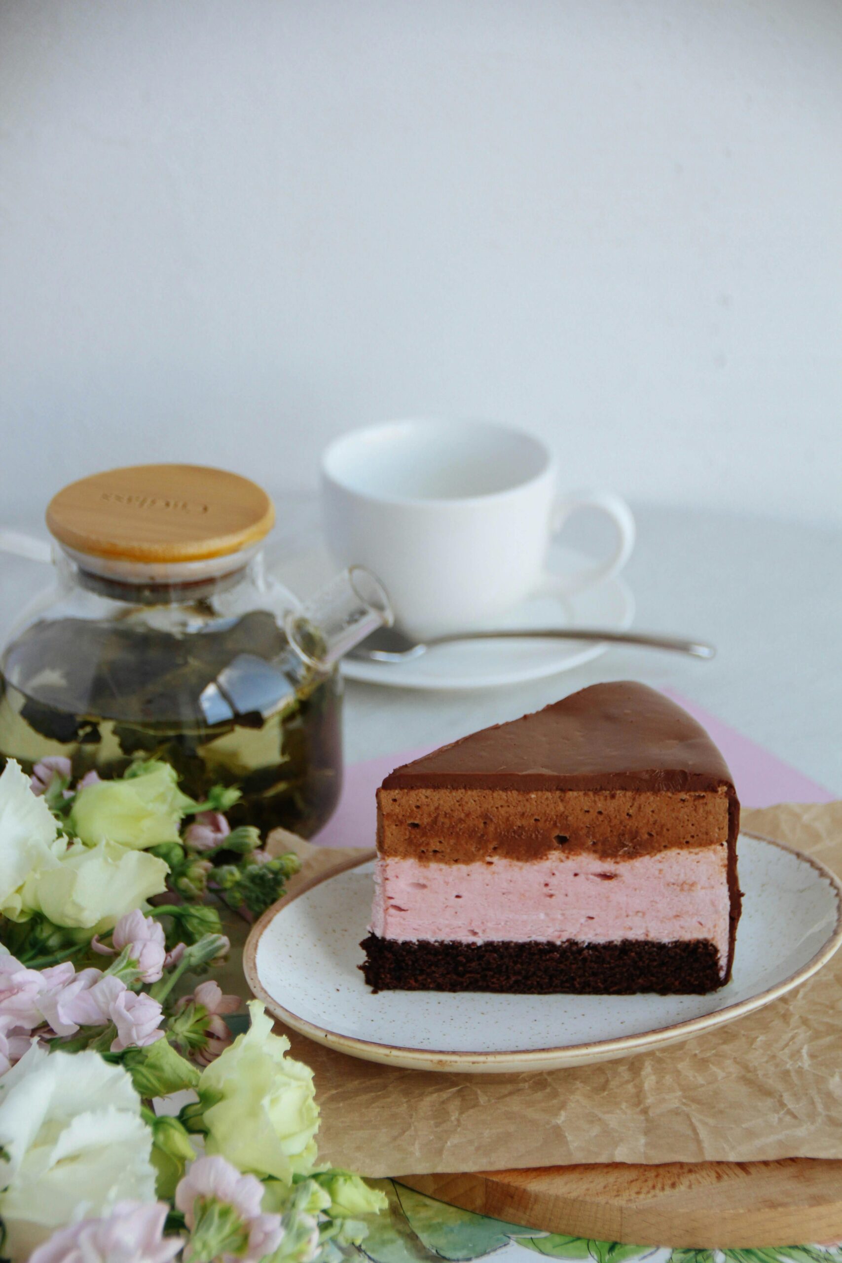 Discover a delectable chocolate and strawberry cheesecake paired with a refreshing cup of green tea.
