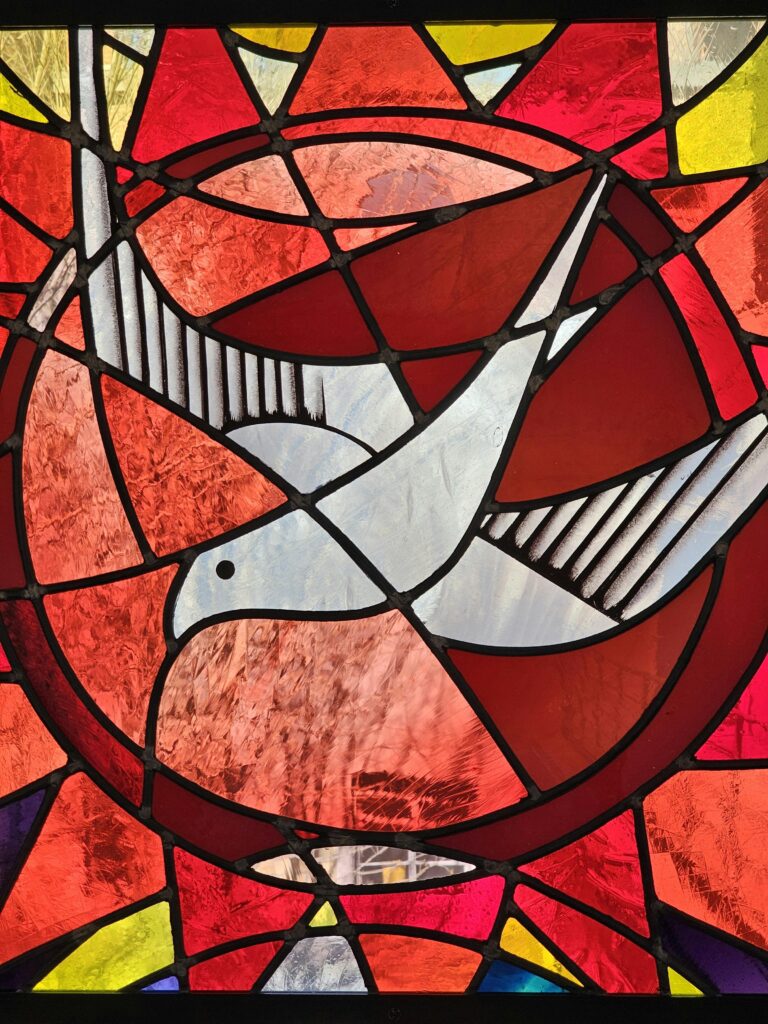 Vibrant stained glass featuring a dove, symbolizing peace and harmony.
