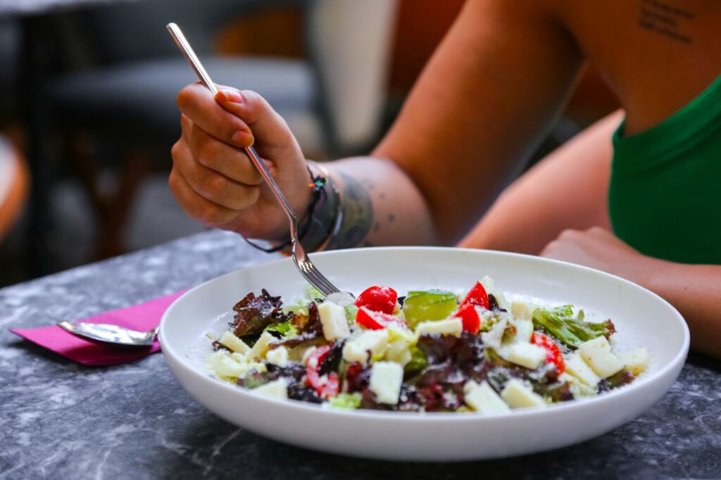 A close-up view of a colorful salad being eaten with a fork indoors. Perfect for food photography.